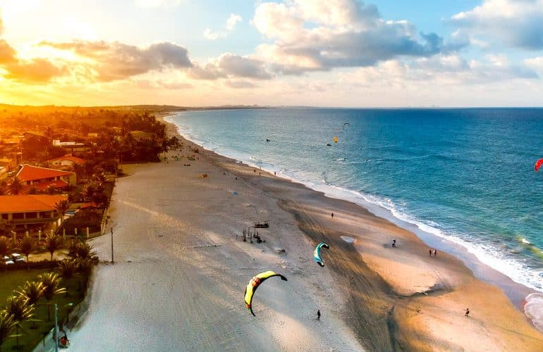 Praia de Fortaleza com mar azul e coqueiros