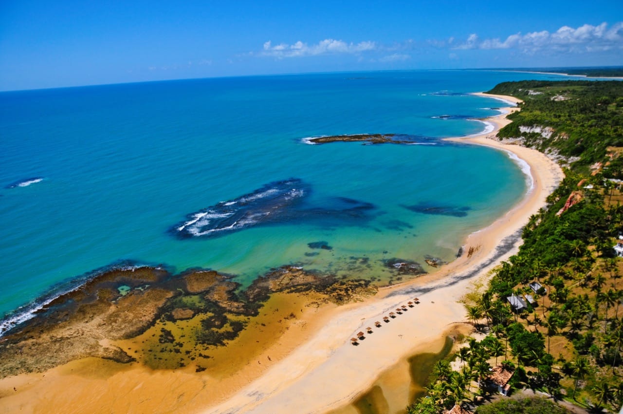 Praia tropical de Porto Seguro com coqueiros e mar azul